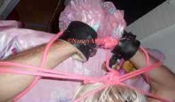 Hands tied up and cuffed above AB Lucinda's head on the nappy changing table.